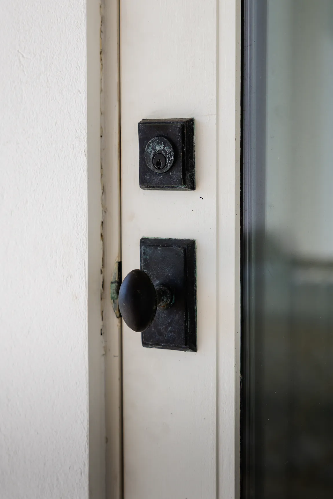 Door hardware before, green corrosion and chalking on the bronze