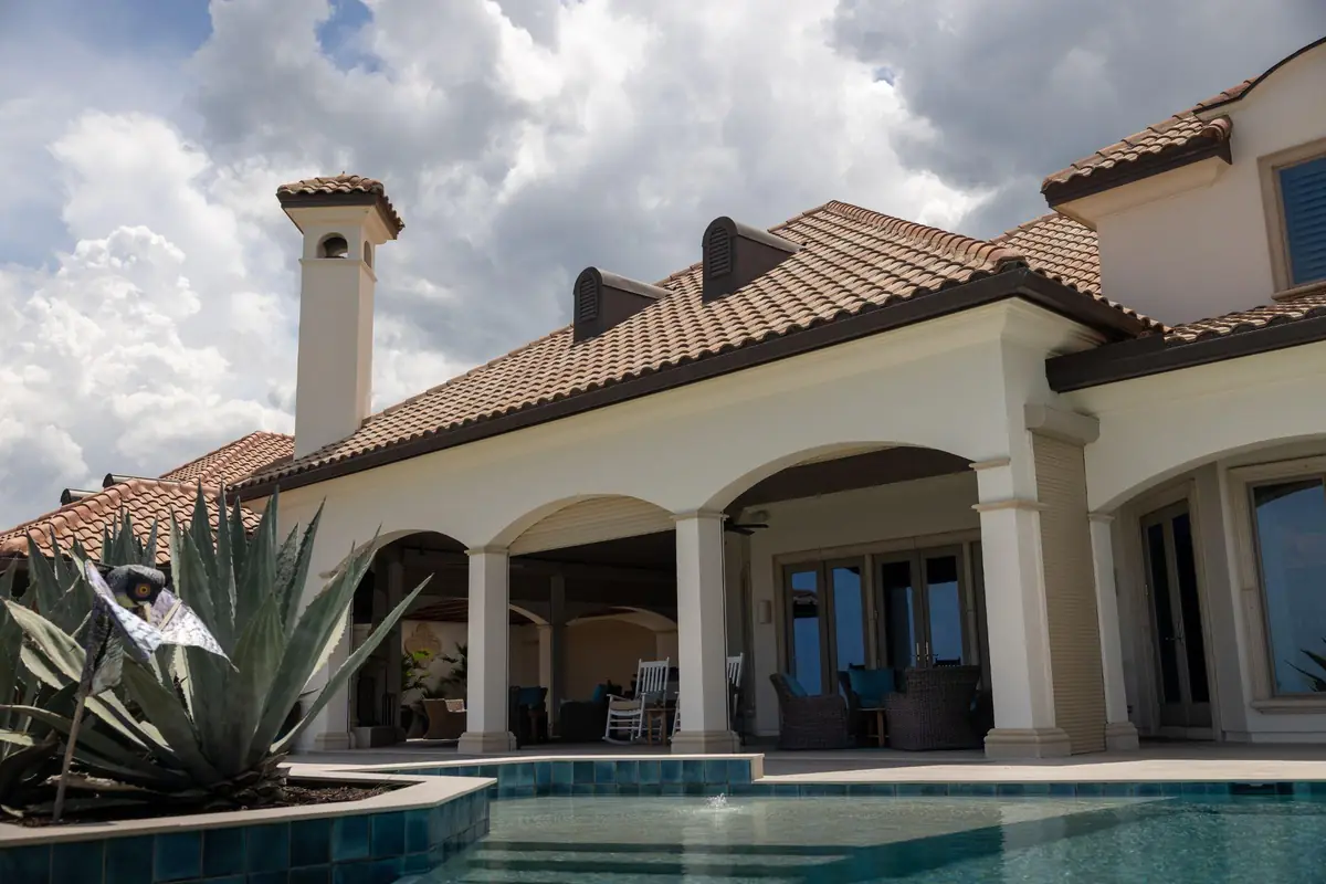 An estate exterior at rest, pool and terrace in warm afternoon light